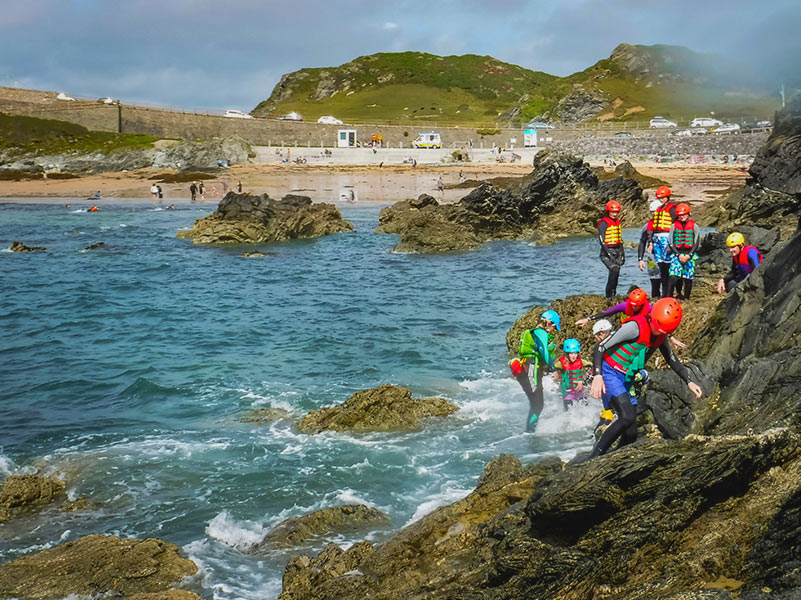 Group of people coasteering in Porth Dafarch Bay